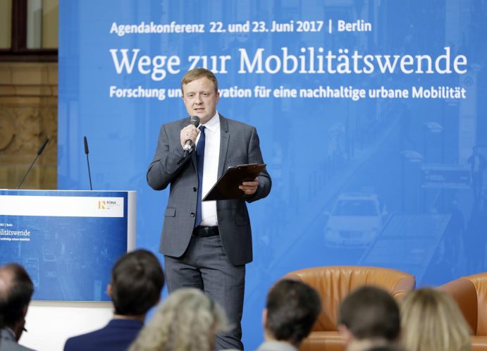 Moderator Peter Schwierz (Chefredakteur bei electrive.net) auf der Agendakonferenz "Wege zur Mobilitätswende" am 22. und 23. Juni 2017 in Berlin Mobilität und urbaner Verkehr befinden sich derzeit in einem dynamischen Wandel. In den Städten entstehen zum einen vielfältige neue Mobilitätsdienstleistungen und Verkehrsangebote, zum anderen verändern sich Mobilitätsmuster und Rahmenbedingungen der Mobilität. Dieser Wandel der Mobilitätswelt erfordert eine verstärkte Einbindung der Forschung, um diesen Wandel mit zu gestalten. Das Bundesministerium für Bildung und Forschung (BMBF) führt daher im Jahr 2017 einen Agendaprozess „Nachhaltige urbane Mobilität" durch. Dieser erfolgt unter Mitwirkung des Bundesministeriums für Verkehr und digitale Infrastruktur (BMVI).
Im Rahmen dieses Prozesses diskutierten 300 Expertinnen und Experten aus Wissenschaft, Wirtschaft, Politik und Zivilgesellschaft auf der "Agendakonferenz: Wege zur Mobilitätswende" über Forschungs- und Umsetzungsbedarfe für eine nachhaltige Entwicklung von Mobilität in Städten.