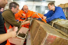 POLARSTERN-Fahrtleiter Prof. Dr. R&uuml;diger Stein (Mitte, orangefarbene Kleidung) und sein Team begutachten im POLARSTERN-Labor den am Lomonossow-R&uuml;cken geborgenen Sedimentkern.