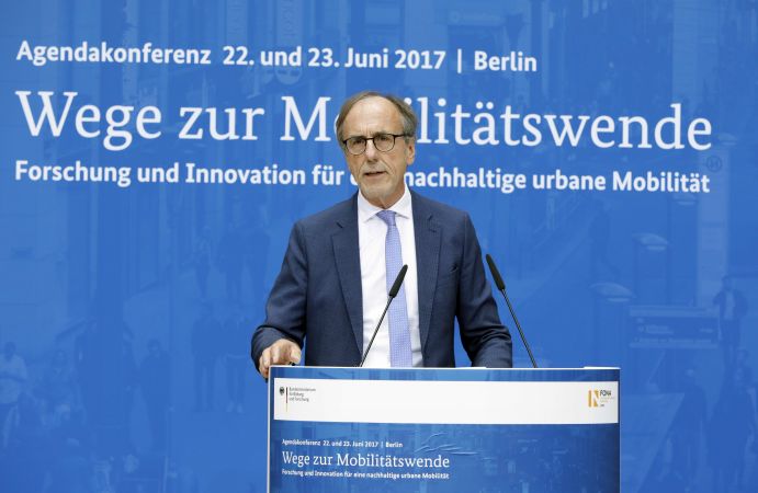 Dr. Karl-Eugen Huthmacher (Leiter der Abteilung 'Zukunftsvorsorge – Forschung für Grundlagen und Nachhaltigkeit', BMBF) auf der Agendakonferenz "Wege zur Mobilitätswende" am 22. und 23. Juni 2017 in Berlin Mobilität und urbaner Verkehr befinden sich derzeit in einem dynamischen Wandel. In den Städten entstehen zum einen vielfältige neue Mobilitätsdienstleistungen und Verkehrsangebote, zum anderen verändern sich Mobilitätsmuster und Rahmenbedingungen der Mobilität. Dieser Wandel der Mobilitätswelt erfordert eine verstärkte Einbindung der Forschung, um diesen Wandel mit zu gestalten. Das Bundesministerium für Bildung und Forschung (BMBF) führt daher im Jahr 2017 einen Agendaprozess „Nachhaltige urbane Mobilität" durch. Dieser erfolgt unter Mitwirkung des Bundesministeriums für Verkehr und digitale Infrastruktur (BMVI).
Im Rahmen dieses Prozesses diskutierten 300 Expertinnen und Experten aus Wissenschaft, Wirtschaft, Politik und Zivilgesellschaft auf der "Agendakonferenz: Wege zur Mobilitätswende" über Forschungs- und Umsetzungsbedarfe für eine nachhaltige Entwicklung von Mobilität in Städten.