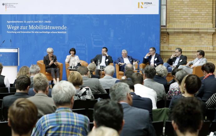 Podiumsdiskussion: Wege zur Mobilitätswende Mobilität und urbaner Verkehr befinden sich derzeit in einem dynamischen Wandel. In den Städten entstehen zum einen vielfältige neue Mobilitätsdienstleistungen und Verkehrsangebote, zum anderen verändern sich Mobilitätsmuster und Rahmenbedingungen der Mobilität. Dieser Wandel der Mobilitätswelt erfordert eine verstärkte Einbindung der Forschung, um diesen Wandel mit zu gestalten. Das Bundesministerium für Bildung und Forschung (BMBF) führt daher im Jahr 2017 einen Agendaprozess „Nachhaltige urbane Mobilität" durch. Dieser erfolgt unter Mitwirkung des Bundesministeriums für Verkehr und digitale Infrastruktur (BMVI).
Im Rahmen dieses Prozesses diskutierten 300 Expertinnen und Experten aus Wissenschaft, Wirtschaft, Politik und Zivilgesellschaft auf der "Agendakonferenz: Wege zur Mobilitätswende" über Forschungs- und Umsetzungsbedarfe für eine nachhaltige Entwicklung von Mobilität in Städten.