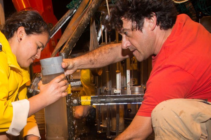 Pedro Martínez Arbizu und Nancy Mercado Salas entnehmen einen der zwölf Kerne mit dem überstehenden Bodenwasser, die mit dem Multicorer vom Meeresboden genommen werden.