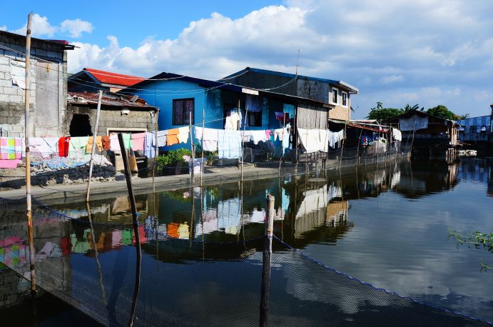 Foto aus dem Jahr 2018 der informellen Siedlung Colo- ong in Valenzuela City, Metro Manila , Philippinen. Klimaresilientes Upgrading steht im Fokus des LIRLAP-Projekts, auf
dem Foto zu erkennen ist die unmittelbare Nähe des Wassers zur informellen Siedlung und die sich daraus ergebende Notwendigkeit zur Anpassung.
