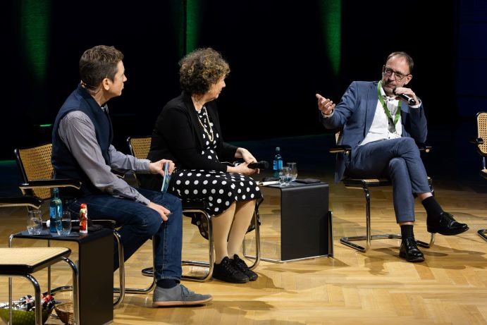 Moderator Johannes Büchs mit Prof. Dr. Diana Pretzell (Erste Bürgermeisterin Stadt Mannheim) und Heiko Thomas (Beigeordneter für Klima und Umwelt, Stadtbetrieb und Gebäude der Stadt Aachen)