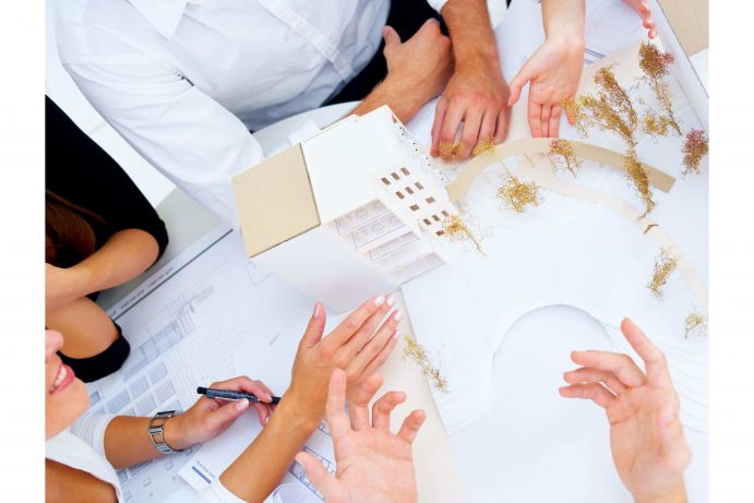 Eine Gruppe Menschen arbeitet an einem Modell f&uuml;r eine Innenstadt