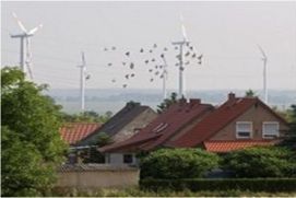 Windkraftanlagen nahe einer Wohnsiedlung.