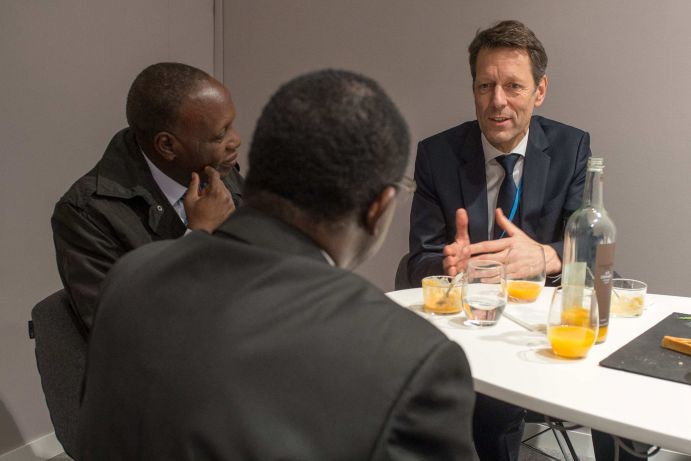Staatssekretär Dr. Georg Schütte (BMBF) im Gespräch mit ministeriellen Vertretern der WASCAL Partnerländer Im westlichen und im südlichen Afrika entstehen zwei regionale Kompetenzzentren für Klimawandel und nachhaltiges Landmanagement - gefördert vom Bundesforschungsministerium. ). Es ist eine einzigartige Initiative in der wissenschaftlichen Entwicklungszusammenarbeit zwischen Afrika und Deutschland. Die Maxime: Forschen mit, statt in Afrika.Für WASCAL (West African Science Service Centre on Climate Change and Adapted Land Use) entstand in Ouagadougou (Burkina Faso) ein neuer Campus mit Laboren und Hörsälen sowie eine Verwaltung in Accra (Ghana). Im Klimakompetenzzentrum Ouagadougou sollen die Forschungsergebnisse aller beteiligten Staaten zusammenlaufen. Vorbilder für die Zentren waren u. a. Forschungsinstitutionen in Deutschland, mit denen ein enger Austausch besteht. Außerdem entstanden im Westen Afrikas zehn Graduiertenprogramme (sechs Doktoranden und vier Masterprogramme). Diese werden von Universitäten in Westafrika in Zusammenarbeit mit deutschen Partneruniversitäten durchgeführt. Inzwischen befinden sich mehr als 160 Nachwuchswissenschaftler in der Ausbildung, von denen bislang bereits 60 erfolgreich die WASCAL-Graduiertenprogramme absolviert haben.Die beiden Klimaforschungszentren in Afrika – SASSCAL und WASCAL – stellten ihre Forschungsarbeit auf der COP21 vor. Staatssekretär Dr. Georg Schütte eröffnete am 8.12. das Side Event und führte Gespräche mit der afrikanischen Delegation. Link zu Side Events des BMBF bei COP 21: https://www.fona.de/de/20545 