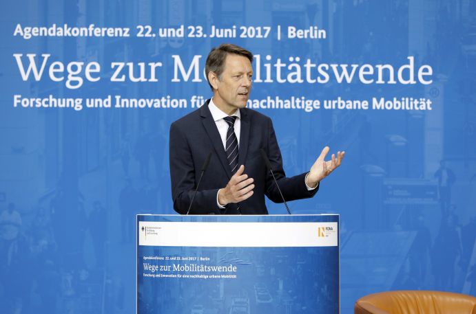 Dr. Georg Schütte (Staatssekretär im BMBF) auf der Agendakonferenz "Wege zur Mobilitätswende" am 22. und 23. Juni 2017 in Berlin Mobilität und urbaner Verkehr befinden sich derzeit in einem dynamischen Wandel. In den Städten entstehen zum einen vielfältige neue Mobilitätsdienstleistungen und Verkehrsangebote, zum anderen verändern sich Mobilitätsmuster und Rahmenbedingungen der Mobilität. Dieser Wandel der Mobilitätswelt erfordert eine verstärkte Einbindung der Forschung, um diesen Wandel mit zu gestalten. Das Bundesministerium für Bildung und Forschung (BMBF) führt daher im Jahr 2017 einen Agendaprozess „Nachhaltige urbane Mobilität" durch. Dieser erfolgt unter Mitwirkung des Bundesministeriums für Verkehr und digitale Infrastruktur (BMVI).
Im Rahmen dieses Prozesses diskutierten 300 Expertinnen und Experten aus Wissenschaft, Wirtschaft, Politik und Zivilgesellschaft auf der "Agendakonferenz: Wege zur Mobilitätswende" über Forschungs- und Umsetzungsbedarfe für eine nachhaltige Entwicklung von Mobilität in Städten.