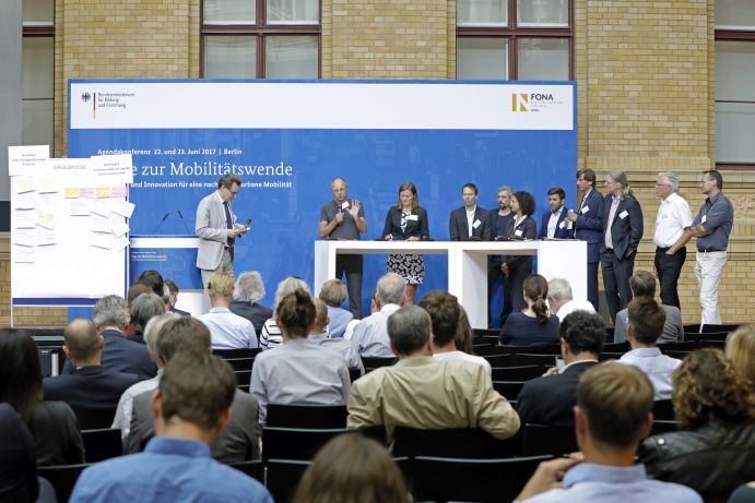 Vorstellung der Ergebnisse der Workshops auf der Agendakonferenz "Wege zur Mobilitätswende" am 22. und 23. Juni 2017 in Berlin Mobilität und urbaner Verkehr befinden sich derzeit in einem dynamischen Wandel. In den Städten entstehen zum einen vielfältige neue Mobilitätsdienstleistungen und Verkehrsangebote, zum anderen verändern sich Mobilitätsmuster und Rahmenbedingungen der Mobilität. Dieser Wandel der Mobilitätswelt erfordert eine verstärkte Einbindung der Forschung, um diesen Wandel mit zu gestalten. Das Bundesministerium für Bildung und Forschung (BMBF) führt daher im Jahr 2017 einen Agendaprozess „Nachhaltige urbane Mobilität" durch. Dieser erfolgt unter Mitwirkung des Bundesministeriums für Verkehr und digitale Infrastruktur (BMVI).
Im Rahmen dieses Prozesses diskutierten 300 Expertinnen und Experten aus Wissenschaft, Wirtschaft, Politik und Zivilgesellschaft auf der "Agendakonferenz: Wege zur Mobilitätswende" über Forschungs- und Umsetzungsbedarfe für eine nachhaltige Entwicklung von Mobilität in Städten.