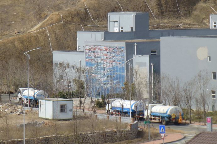 SEMIZENTRAL-Anlage in Qingdao, China: Tankwagen holen aufbereitetes Abwasser ab SEMIZENTRAL-Anlage in Qingdao, China: Tankwagen holen aufbereitetes Abwasser ab, welches in dem Wassermangelgebiet zur Bewässerung von öffentlichen Grünanlagen genutzt wird.
Das Foto zeigt die SEMIZENTRAL-Anlage, das weltweit erste semizentralen Wasserver- und –entsorgungszentrum, welche ein wichtiger Teilerfolg der über 10-jährigen Forschungs- und Entwicklungsarbeit des Verbundprojekts SEMIZENTRAL ist. Das Verbundprojekt SEMIZENTRAL ist Teil des „Forschungs- und Innovationsprogramms Sauberes Wasser“, das in Zusammenarbeit zwischen der Volksrepublik China und der Bundesrepublik Deutschland entstanden ist. Finanziert wird das Programm vom Ministerium für Wissenschaft und Technologie (MoST) der VR China und dem Bundesministerium für Bildung und Forschung (BMBF) im Rahmen der Wasserforschung, die einen Schwerpunkt der Forschung für Nachhaltige Entwicklung (FONA) bildet. Das Programm „Sauberes Wasser“ deckt Inhalte der Wasserversorgung, Abwasserbehandlung, dem Schutz der natürlichen Wasserressourcen und der sauberen industriellen Produktion ab. Zur erfolgreichen Durchführung unterstützt ein Projektbüro seit 2012 an der Tongji Universität Shanghai das Projekt.
