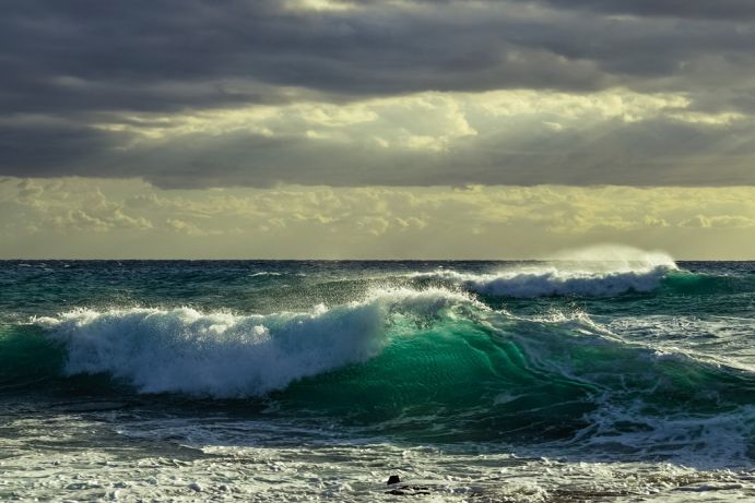 Ozeane und Klima: die gemeinsame Bekanntmachung wird von acht europäischen Ländern unterstützt. Wellen im Meer mit bewölktem Himmel im Hintergrund.