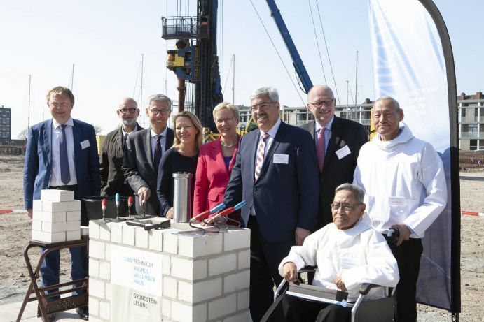 Grundsteinlegung AWI-Technikum Rasmus-Willumsen-Haus. v.l.n.r.: Karsten Wurr (AWI Verwaltungsdirektor), Johannes Kister (ksg Architekten), Carsten Sieling (Präsident des Senats der Freien Hansestadt Bremen), Antje Boetius (AWI-Direktorin), Eva Quante-Brandt (Wissenschaftssenatorin Bremen), Melf Grantz (Oberbürgermeister Bremen), Michael Meister (Staatssekretär BMBF), Hans Peter Willumsen (Neffe des Namensgebers), Johan Willumsen (Großneffe des Namensgebers). Mehrere Personen stehen um den "Grundstein" herum.