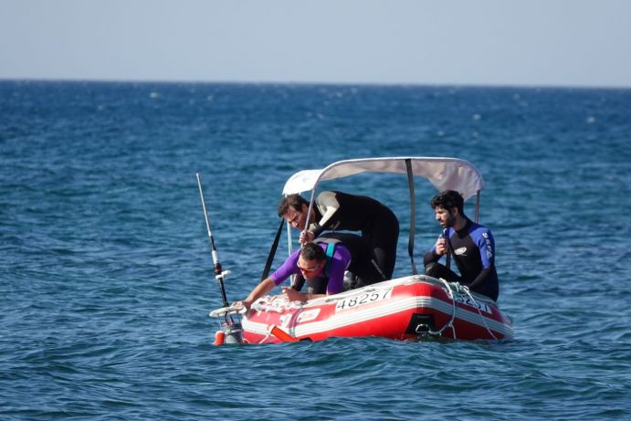 Drei M&auml;nner auf einem rote Boot setzen "Drifter" im Mittelmeer aus.&nbsp;