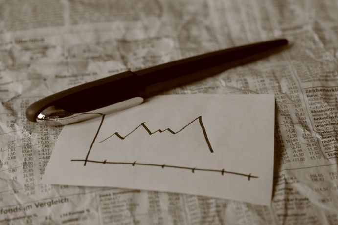 Kugelschreiber zeichnet Kurve zu abfallendem Börsenkurs 