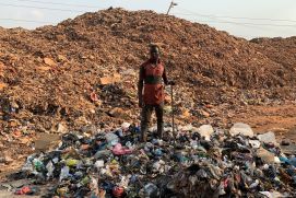 Ein Mann steht auf einer Müllkippe von Siedlungsabfällen in Ghana, Afrika