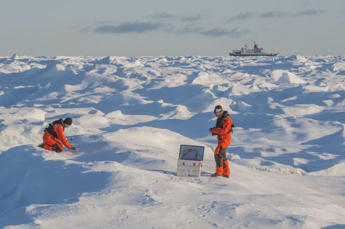 Sascha Flögeö (l) und Johannes Lemberg sammeln Schnee Proben für eine wissenschaftliche Studie und Publikation über Plastik Verschmutzung in der Arktis. Im Hintergrund: die Polarstern. 