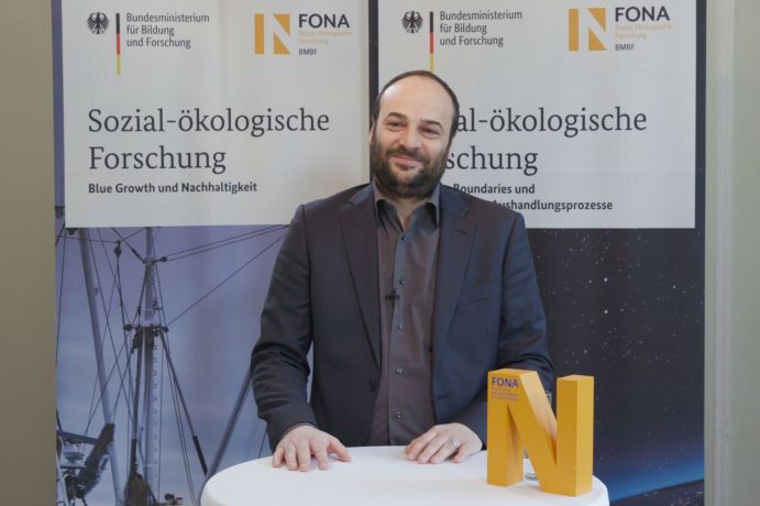 Dr.-Ing. Grischa Beier erforscht steht an einem Tisch, auf dem das FONA-N steht.