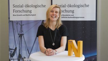 Prof. Dr. Melanie Jaeger-Erben steht an einem Tisch.