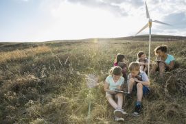 Schulkinder diskutieren über das Modell eines Windrades 