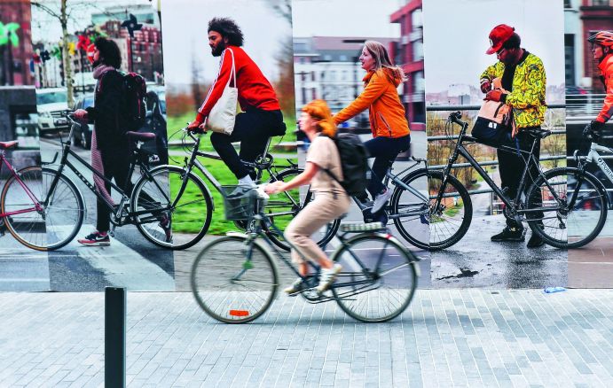 Radfahrerin vor Werbeschild für nachhaltige Mobilität