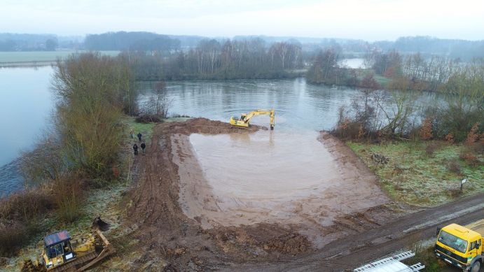 Das Projekt BAGGERSEE bewegte 12.000 Kubikmeter Erde, um in steilscharigen Baggerseen Flachwasserzonen zu schaffen. Diese werden nun erfolgreich von Pflanzen und Tieren besiedelt. Ein Baggersee wird am Ufer mit Erde aufgeschüttet, um Flachwasserzonen für Pfnazen und Tiere zu schaffen.