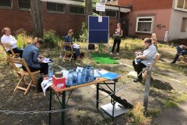 Gruppe von Menschen sitzen im Freien und planen.