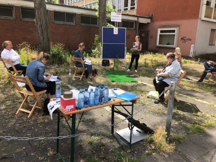Ko-Planung des Projekts iResilience unter Coronabedingungen für ‚die Kasemattenstraße von Morgen!‘. Gruppe von Menschen sitzen im Freien und planen.