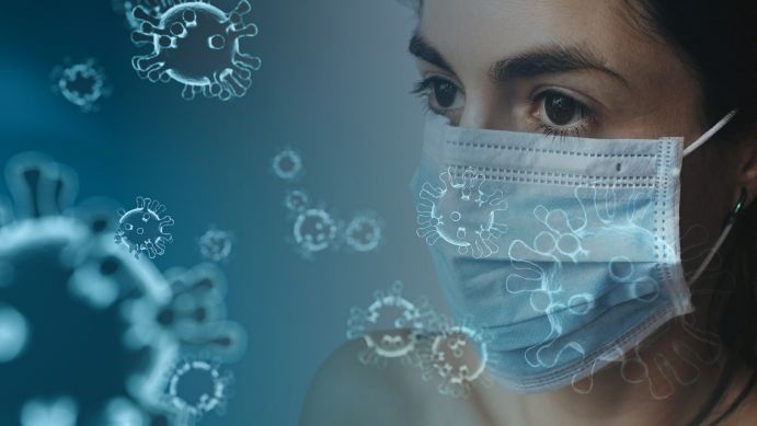 Das BMBF-Projekt CoroMoni vernetzt die nationale und internationale Forschung zum Corona-Monitoring über den Abwasserpfad Frau mit Maske schaut auf grafisch dargestellte SARS-CoV-2 Erreger