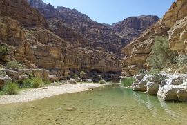 River canyon with rocky cliffs and green water springs