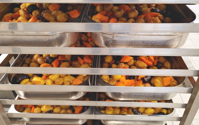 Gastronormbehälter in der Großküche, gefüllt mit einer vielfältigen Kartoffelauswahl