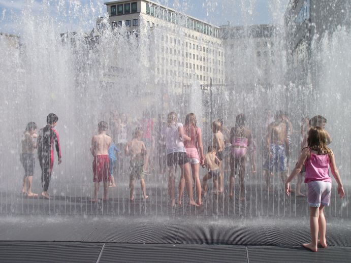 Großstadtkinder kühlen sich in Wasserspielen ab