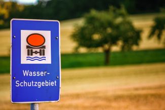 Schild mit Hinweis Wasserschutzgebiet vor verschwommener Landschaft