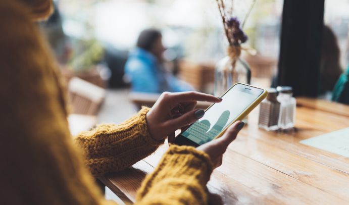 Nachhaltigkeit und Digitalisierung - Forschungsfeld der Nachwuchsgruppe in der Sozial-ökologischen Forschung des BMBF Mädchen am Tisch mit Handy in der Hand