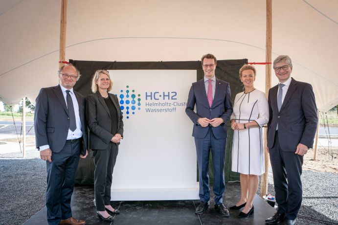 Projektleiter Peter Wasserscheid, BMBF-Staatssekretärin Judith Pirscher, Ministerpräsident Hendrik Wüst, nordrhein-westfälischen Wissenschaftsministerin Ina Brandes und Wolfgang Marquardt (v. l. n. r. ) beim Startschuss für HC-H2. Verteterinnen und Vertreter verschiedener Institutionen enthüllen das Logo des Clusters.