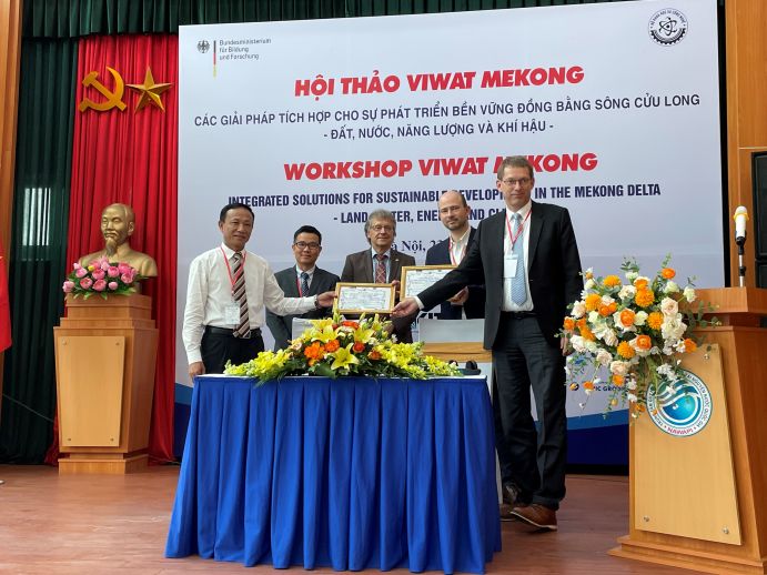 Offizielle Übergabe der im deutsch-vietnamesischen Projekt ViWaT-Mekong installierten Grundwassermessstation an das NAWAPI (National Center for Water Resources Planning and Investigation); von links nach rechts: Dr. Tong Ngoc Thanh (NAWAPI), Dr. Luong Dinh Thang (MOST), Dr. Helmut Löwe (BMBF), Felix Grimmeisen (SEBA Hydrometrie GmbH), Prof. Stefan Norra (Universität Potsdam) Fünf männliche Personen stehen auf einem Podium und halten Urkunden in der Hand