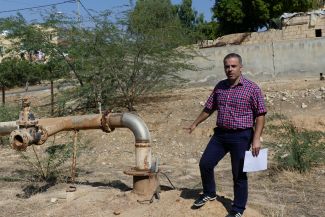 Dr. Hamdan steht neben einem Grundwasserbrunnen