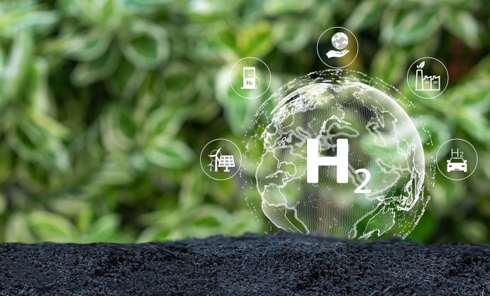 Das Projekt hyBit untersucht am Beispiel des Bremer Industriehafens, wie eine Wasserstoffökonomie ganzheitlich gedacht und aufgebaut werden kann. Das Bild zeigt eine Weltkugel mit der Aufschrift H2. Darum herum sieht man mehrere Symbole für erneuerbare Energien, Wasserstofftankstelle, Wasserstoffauto etc. Im Hintergrund verschwommen die Blätter von Pflanzen.