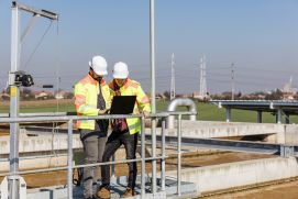 Ingenieure arbeiten an Wasseraufbereitungsanlage mit Laptop