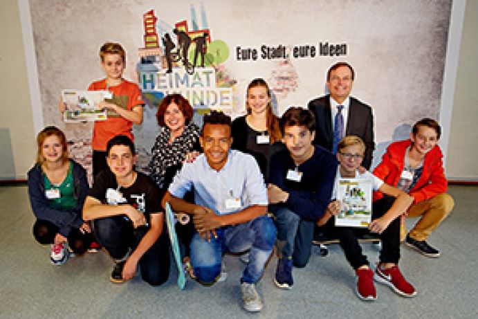 Thomas Rachel, Parlamentarischer Staatssekretär im Bundesministerium für Bildung und Forschung, Ursula Dreeser, Schulleiterin der inklusiven 5. Gesamtschule Bonn, Schülersprecherin Luisa Klidis sowie weitere Schülerinnen und Schüler beim Auftakt der Heimatkunde-Aktion im Wissenschaftsjahr 2015 – Zukunftsstadt.