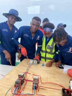 Daniel Ndayamohamba verdrahtet mit seinen Kameraden Schaltkreise eines Vorwärts- und Rückwärtsmotors.