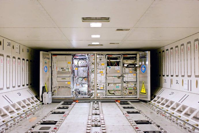 CARIBIC Messcontainer im Frachtraum des Lufthansa Airbus A340-600 Das Projekt CARIBIC (Civil Aircraft fort he Regular Investigation oft he atmosphere Based on an Instrument Container) nutzt einen 1,5 Tonnen schweren Messcontainer um weltweit Messungen in der Atmosphäre vorzunehmen. An dem in Deutschland entwickelten Projekt sind sechs nationale (das Karlsruher Institut für Technologie, das Max -Planck-Institut für Chemie, das Leibniz Institut für Troposphärenforschung, Leipzig, die Abteilung Physik der Atmosphäre des Deutschen Zentrums für Luft und Raumfahrt, die das Institut für Umweltphysik der Universität Heidelberg und das Institut für Umweltphysik des Helmholtz-Zentrums Geesthacht) und sechs internationale Partner beteiligt. Koordinator ist das Karlsruher Institut für Technologie. Das fliegende Labor reist monatlich an Bord des Airbus A-340-600 „Leverkusen“ der Lufthansa im Frachtraum mit. Ein speziell angefertigtes Einlasssystem am Flugzeugbauch leitet während des gesamten Fluges Luft- und Teilchenproben sowie Wetterdaten an die Instrumente im Inneren des Containers weiter. Die Geräte messen über fünfzig klimarelevante Spurengase sowie Wasserdampf und Schwebteilchen in der Atmosphäre. Die detaillierten Daten helfen herauszufinden, wo die Quellen von Verunreinigungen liegen und wie sich die Atmosphäre selbst reinigt.Projekt: CARIBIC (www.caribic.de) The CARIBIC project is integrated in IAGOS (www.iagos.org)Aufnahmeort, Jahr: im Frachtraum des Lufthansa Airbus A340-600, 2011